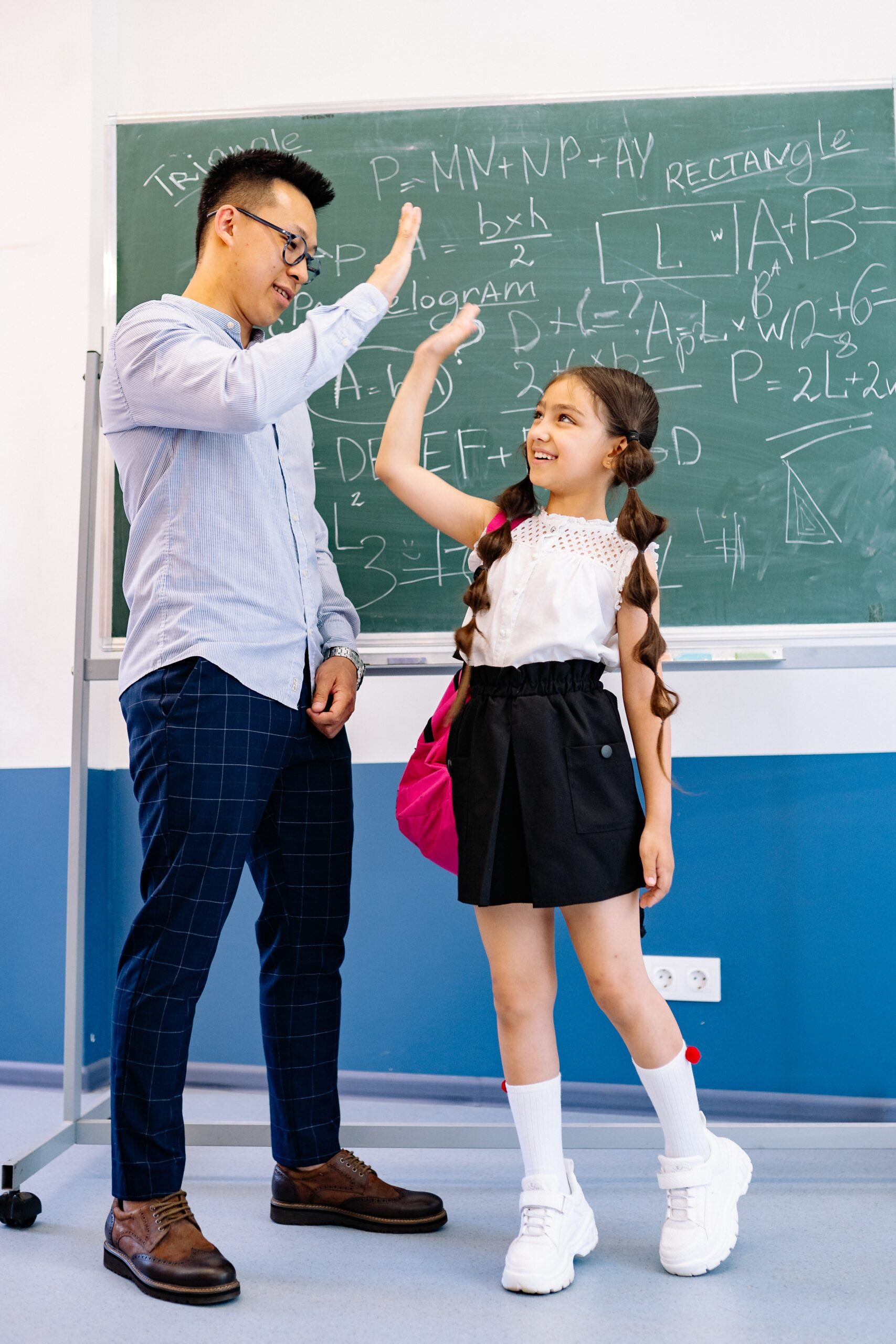 Teacher giving hive five to student